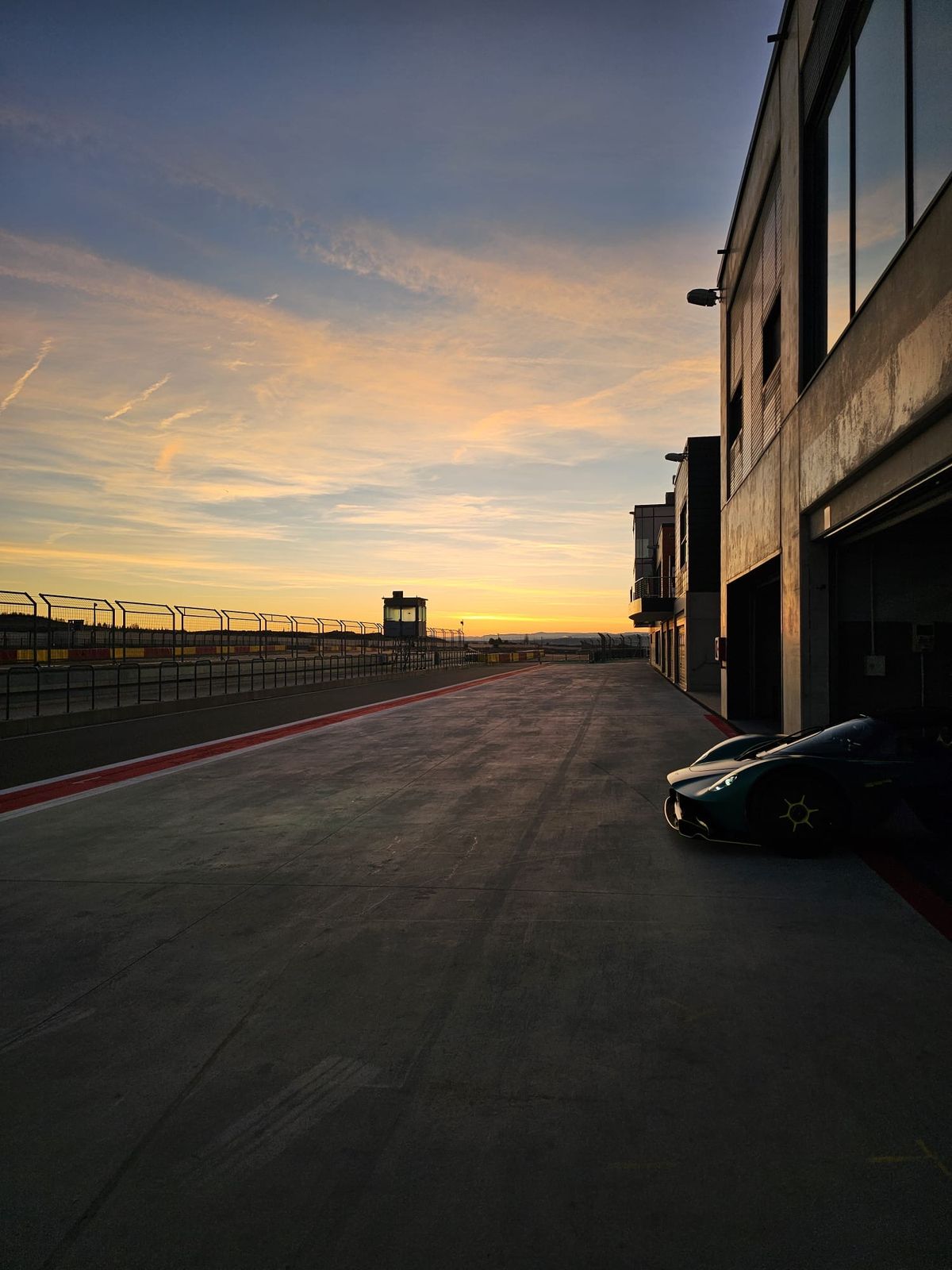 An empty pit lane at sunset before a race weekend